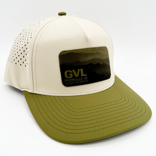 Beige and green trucker cap with 'GVL' and Greenville, SC over a monochromatic mountain landscape view
