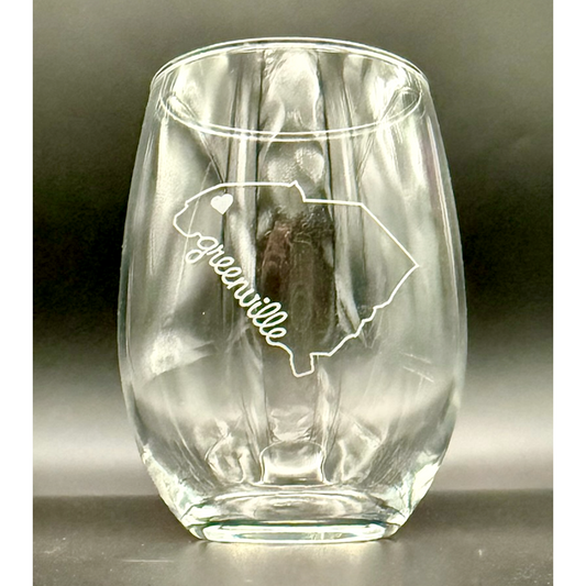 Clear glass stemless wineglass with engraved outline of South Carolina and 'Greenville' script text within state outline with heart at the geographic location of Greenville