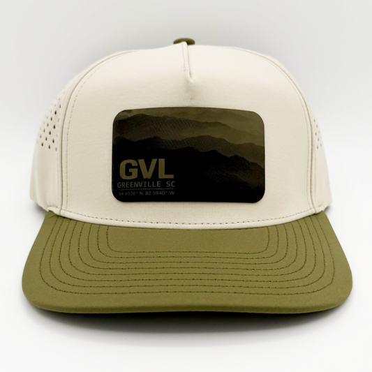 Beige and green trucker cap with 'GVL' and Greenville, SC over a monochromatic mountain landscape view